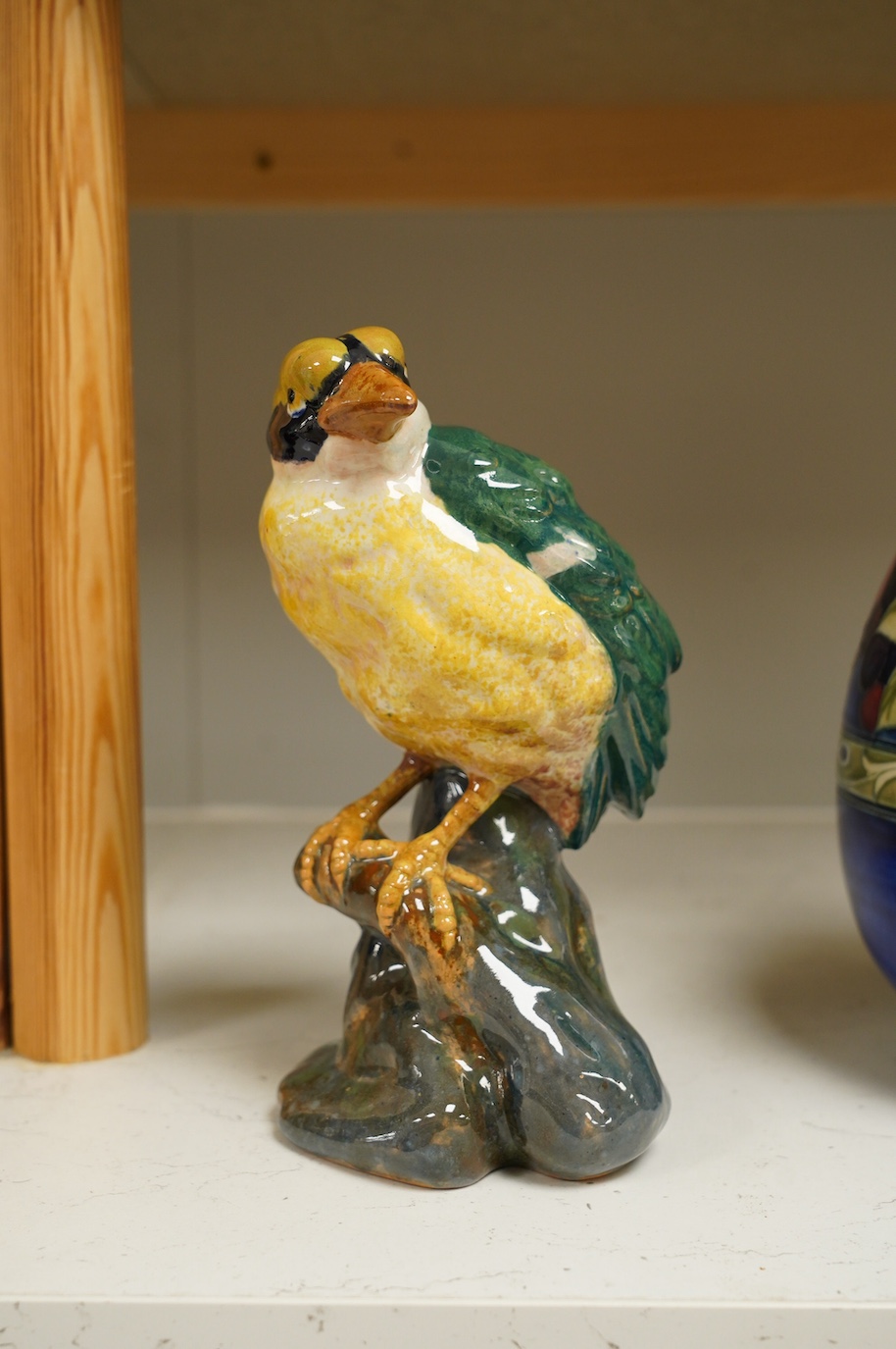 In the manner of Karlsruhe, an Austrian or Italian faience hand painted perching bird, impressed 1532 DO16 etc., 21cm high. Condition - fair to good, minor chips to base